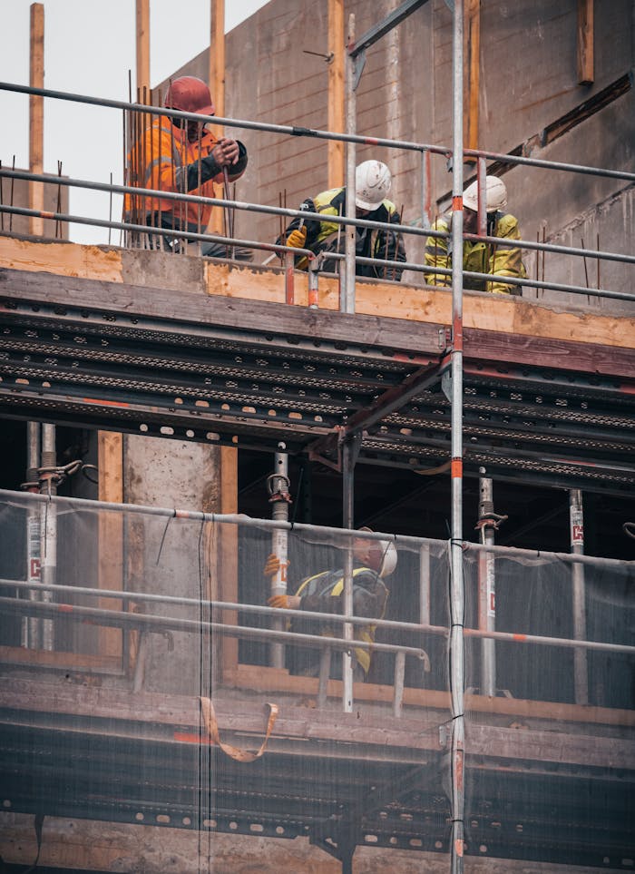 Construction workers engage in building tasks on a scaffold in Hamburg.